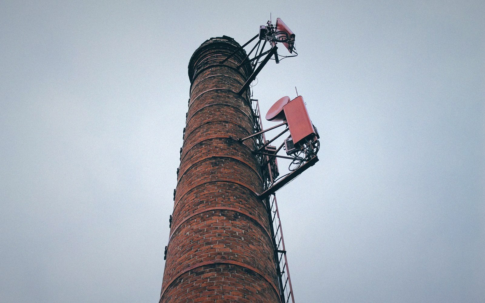 An installer bolting a small wireless dish to a gable end