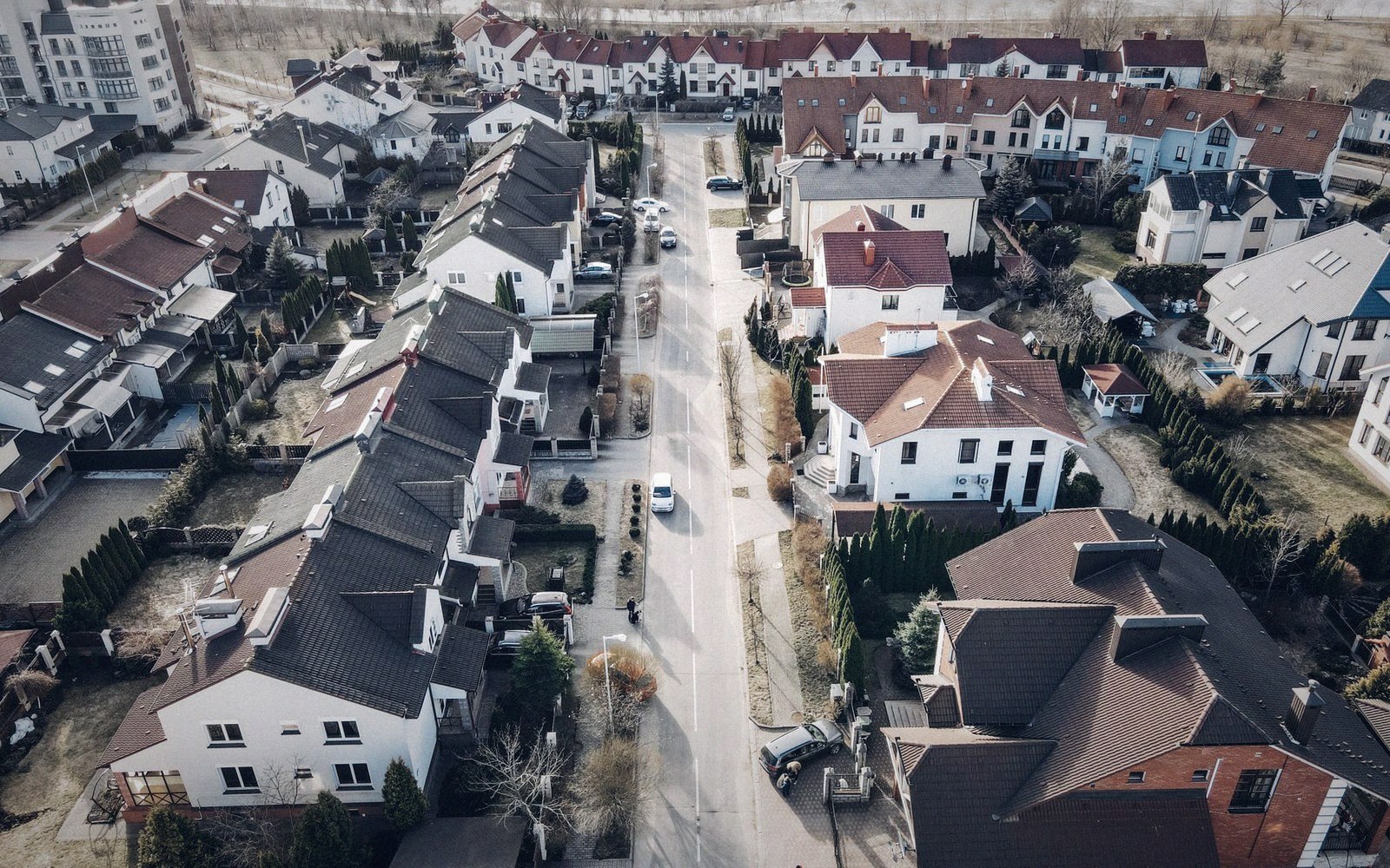 Aerial view of a suburban street lined with detached houses and pitched roofs